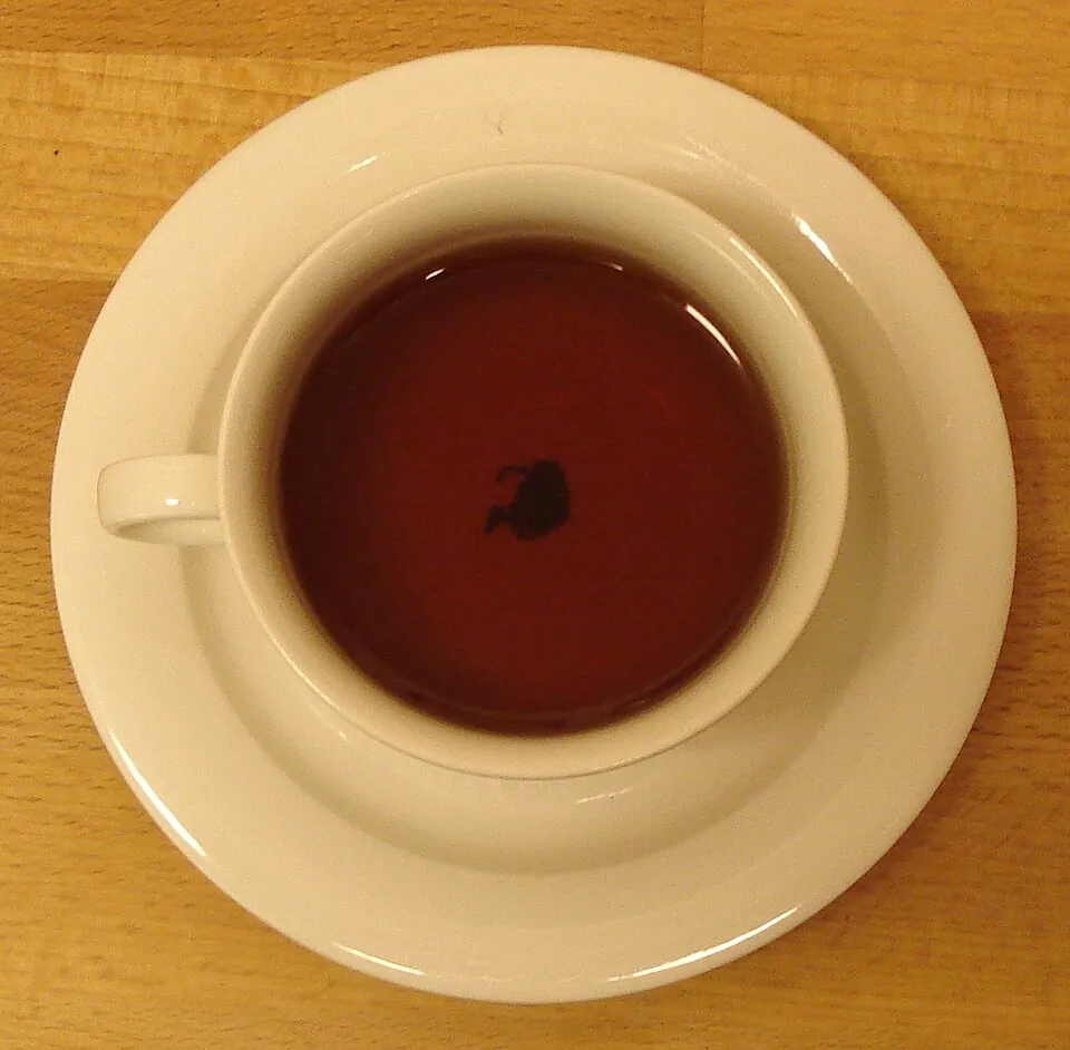 木のテーブルに置かれた紅茶のカップ