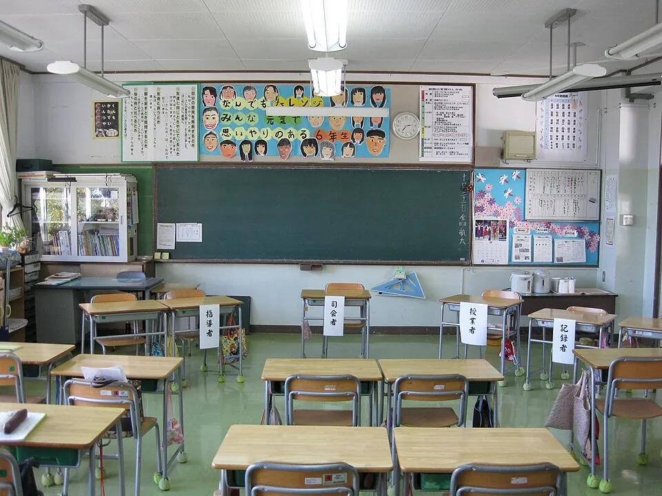 誰もいない教室に並ぶ机と黒板