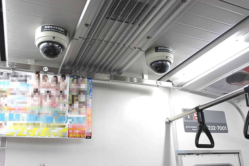 電車の天井に取り付けられた「防犯カメラ作動中」の表示があるドーム型カメラ