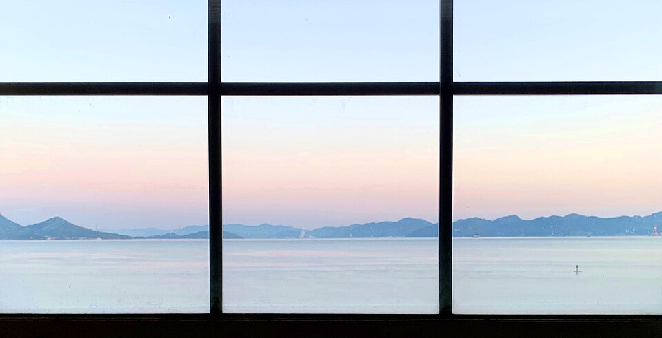 夜明けの海が見える寝室の窓